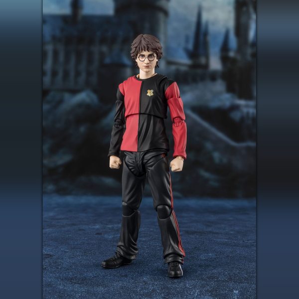 Harry Potter action figure in his red and black Triwizard Tournament outfit against a blurred Hogwarts background