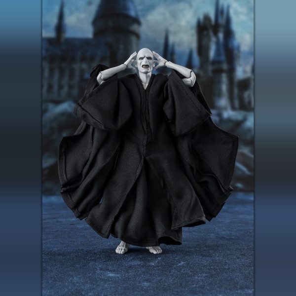 Lord Voldemort action figure in flowing black robes with hands to his head, standing before a dark castle
